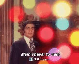 a man in a suit and tie is standing in front of a bunch of lights and says main shayari to nahi