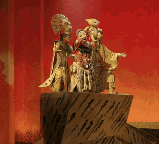 a statue of a man holding a teddy bear and another man holding a lion 's head