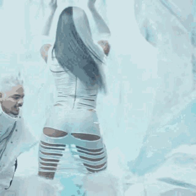 a man is standing next to a woman in a white dress who is dancing .