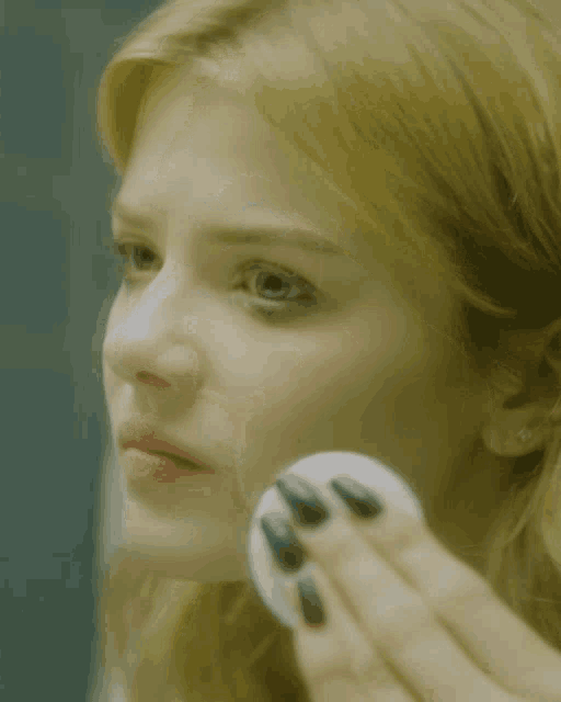 a woman wipes her nose with a napkin