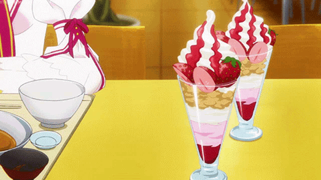 two glasses of ice cream with strawberries and whipped cream