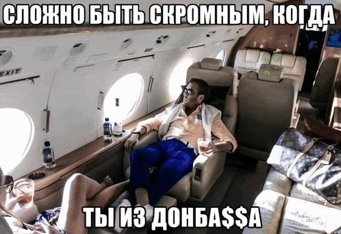 a man sits in a chair on a plane with a woman laying on the floor and a caption in russian