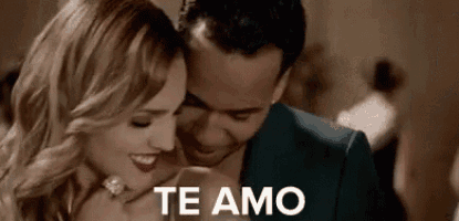 a man and a woman are hugging each other in a room and the man is saying `` te amo '' .