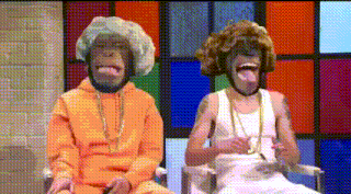 a man and a chimpanzee are sitting next to each other with their tongues out