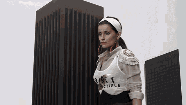 a woman stands in front of a building that says kmag