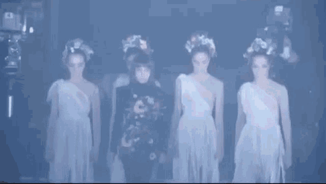 a group of women in white dresses are standing next to each other .