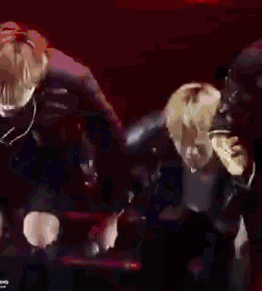 a blurry picture of a man in a black jacket standing in a dark room