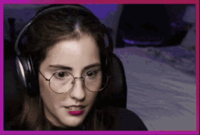 a woman wearing glasses and headphones is looking at the camera
