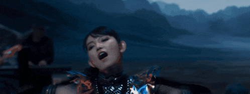 a group of girls are dancing in front of mountains at night