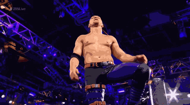 a shirtless wrestler stands on one leg with his arms outstretched in front of a sign that says 206live