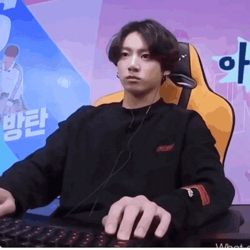 a young man is sitting in a chair playing a video game while wearing headphones .
