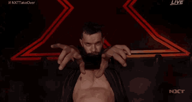 a man with a beard is pointing at the camera while wearing a black jacket .