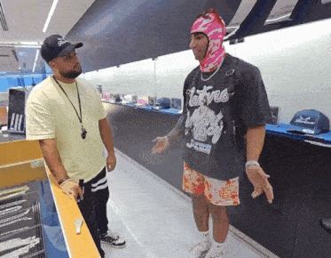 a man wearing a native boy shirt talks to another man in a store