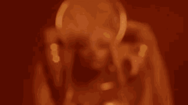 a blurry picture of a person wearing headphones and a ring around their neck .