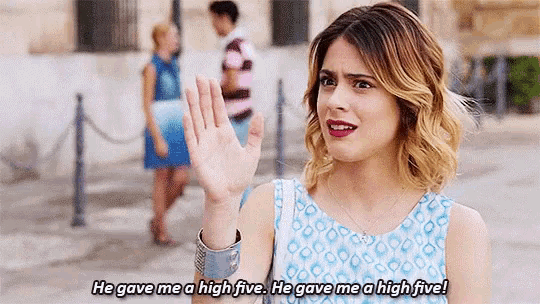 a woman in a blue dress is giving a high five to a man .