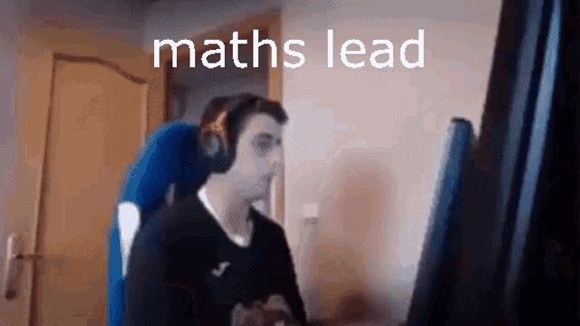 a man wearing headphones sits in front of a computer with the words maths lead written on the screen