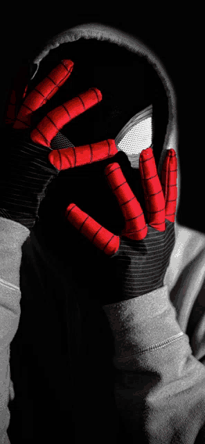 a black and white photo of a person wearing a spiderman glove