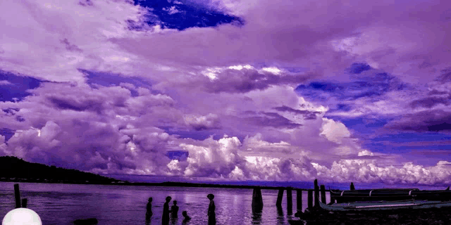 a purple sky over a body of water with boats in the water