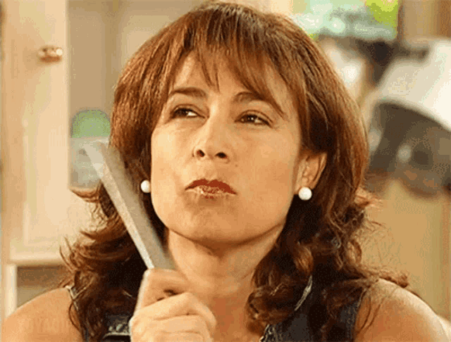 a woman is holding a knife in her right hand