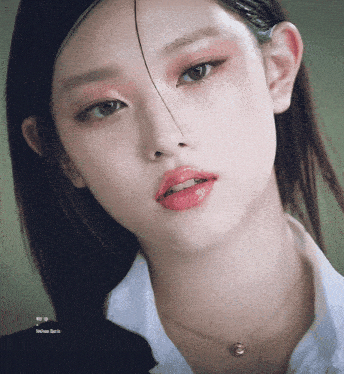 a close up of a woman 's face with a necklace and a white shirt with the word martin on the bottom right