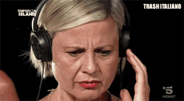 a woman is wearing headphones and making a funny face