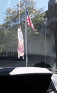 a car air freshener hangs from a pole in front of a window
