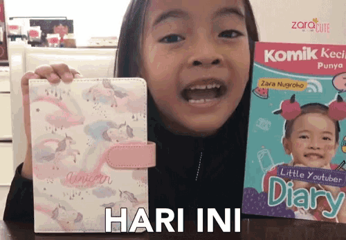 a little girl is holding a unicorn wallet next to a book titled little youtuber diary