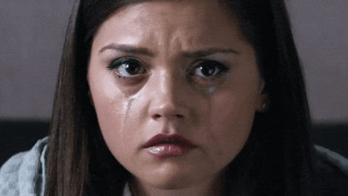 a close up of a woman 's face with a tear running down her cheek