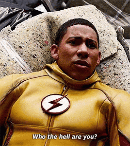 a man in a yellow flash suit is laying on a pile of rubble and says who the hell are you ?