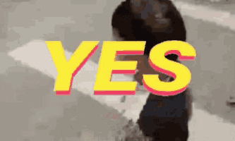 a yellow and pink sign that says yes with a person in the background