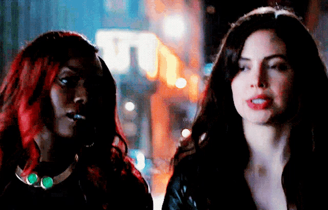 two women are standing next to each other in front of a sign that says ' u.t. '