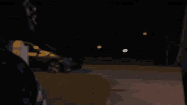 a man in a blue and yellow striped shirt stands in the dark