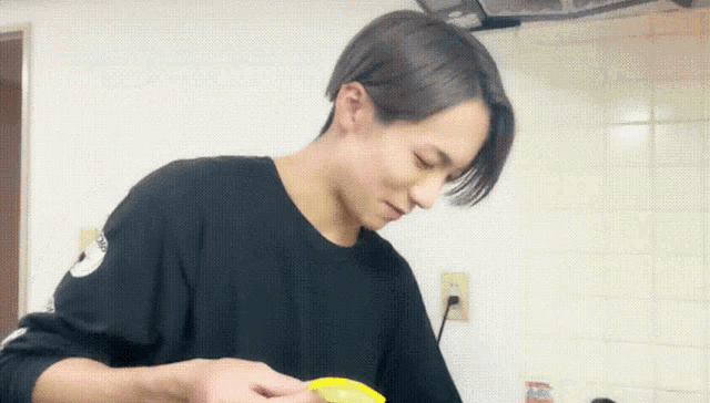 a man in a black sweater is peeling a banana