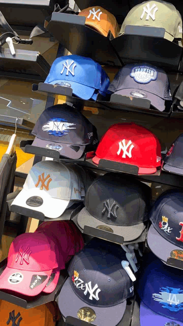 a bunch of new york yankees hats are displayed on a shelf