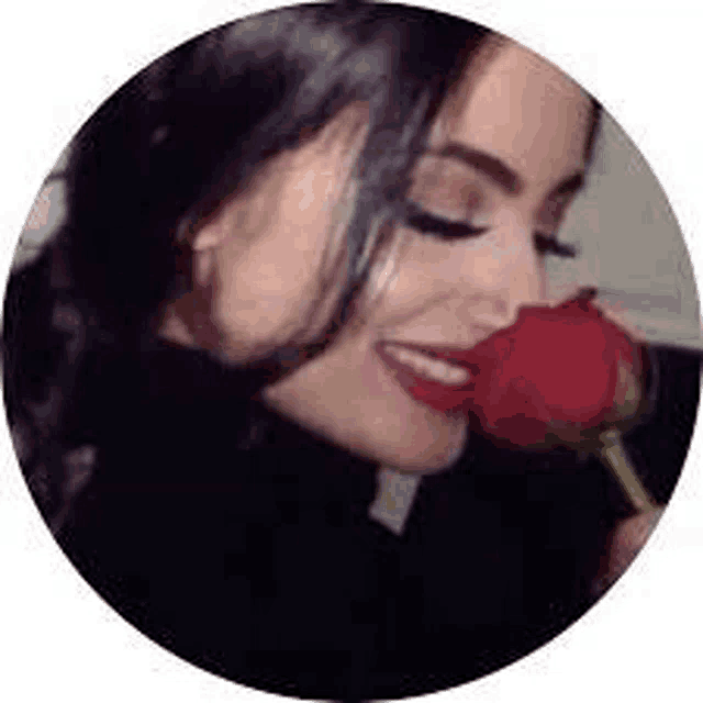 a woman is holding a red rose in her mouth .