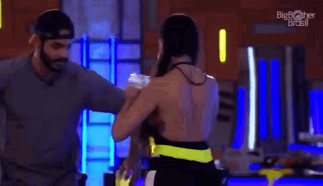 a man and a woman are dancing together in front of a blue background .
