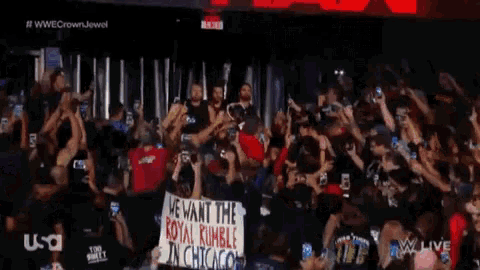 a crowd of people holding up signs that say we want the royal rumble in chicago