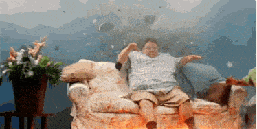 a man is sitting on a couch with his arms outstretched in front of a fire