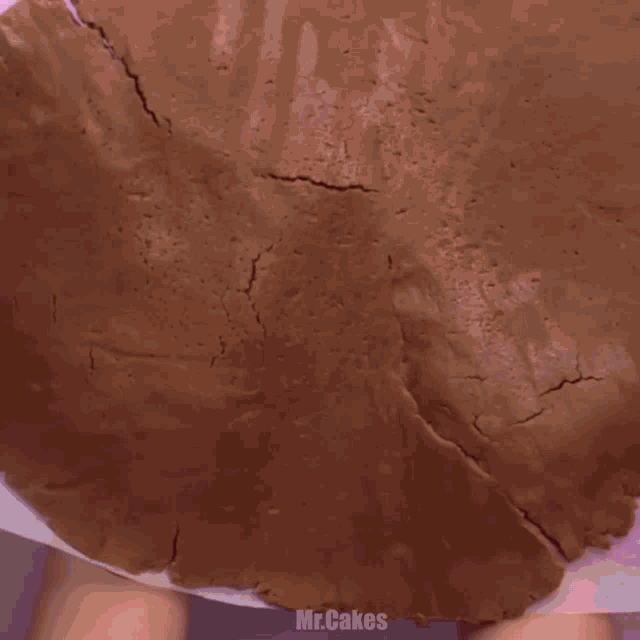 a pie crust on a pink surface with mr.cakes written on the bottom