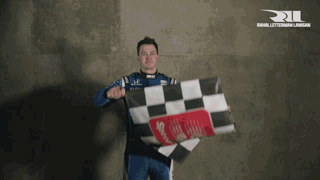 a man holding a checkered flag in front of a wall that says raul letterman lane