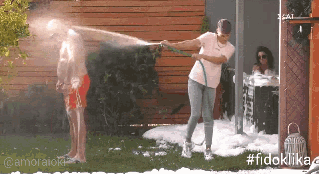 a woman spraying a man with a hose with the hashtag #fidoklika
