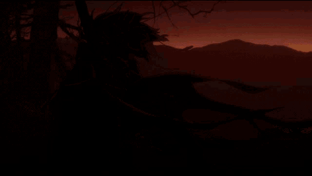 a silhouette of a person with wings sitting in a tree