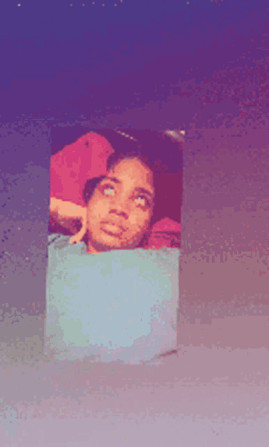 a picture of a woman laying on a bed with a blue background