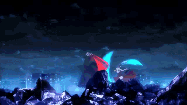 a couple of people standing on top of a pile of rocks in the dark
