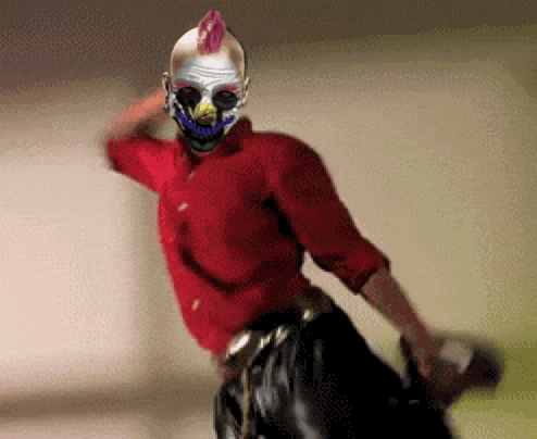 a man wearing a clown mask and a red shirt is holding a bottle