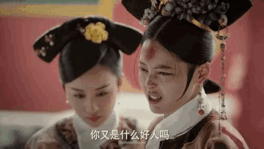 two women are standing next to each other in a room and one has a bloody face .