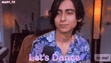 a man in a floral shirt is holding a cell phone and saying let 's dance