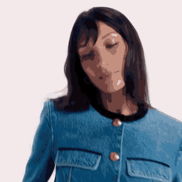a woman wearing a blue jacket with gold buttons on the front