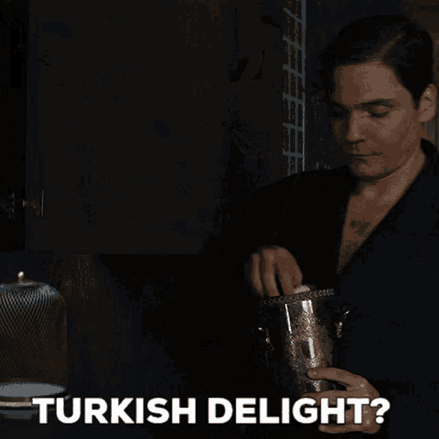 a man in a bathrobe is holding a bucket of ice and the words turkish delight are above him