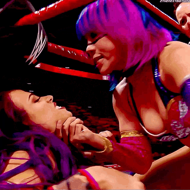 a woman with purple hair is kissing another woman in the ring